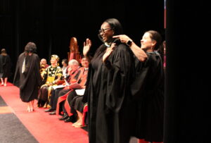 Nursing graduate being hooded on stage